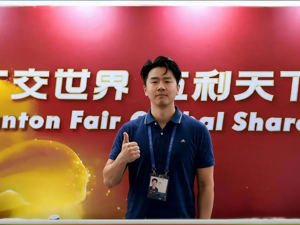 Pupulan team member at the Canton Fair — "Canton Fair, Global Share" backdrop